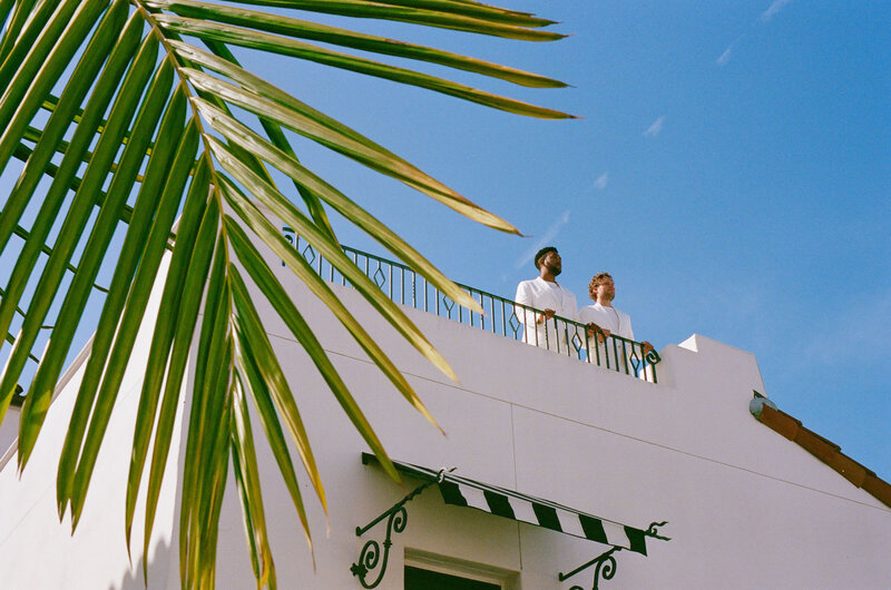 Image from the ground of a couple standing on top of a roof.