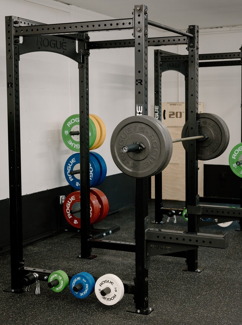 woman holding barbell on shoulders