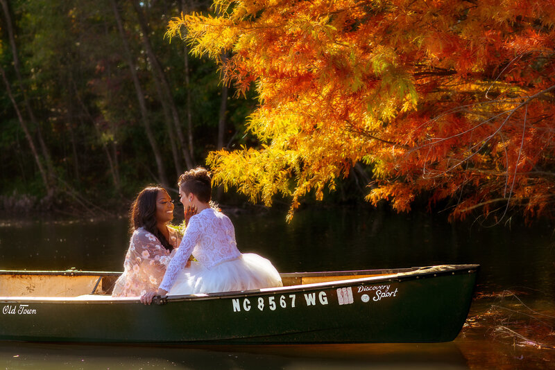 LGBT interracial couple eloping in canoe with fall colors