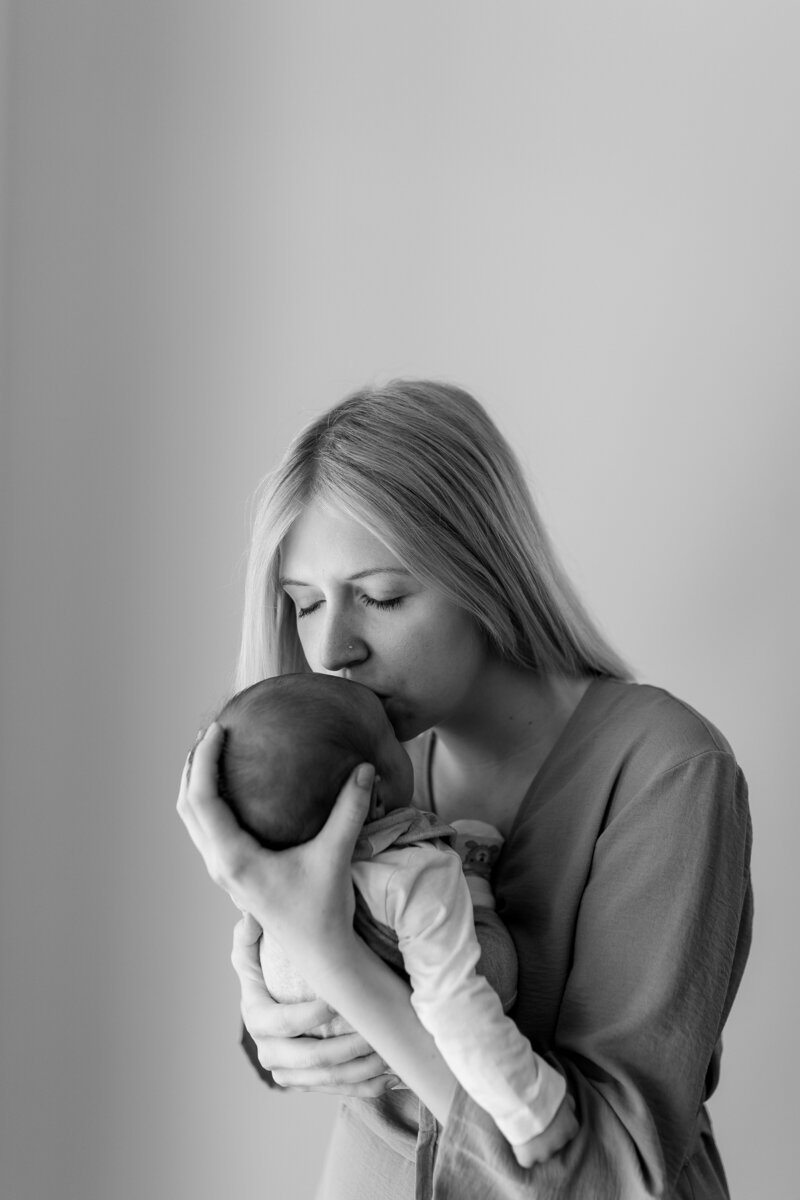 Schearz weiss Bild von Mutter wie sie Baby im Arm haelt und kuesst