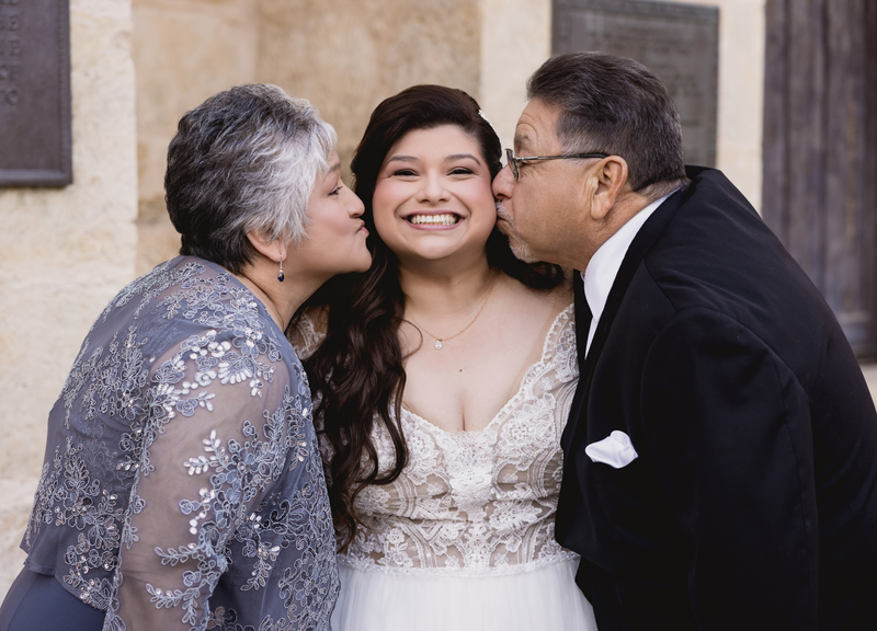 Mother and Father of the Bride Kissing their Daughter
