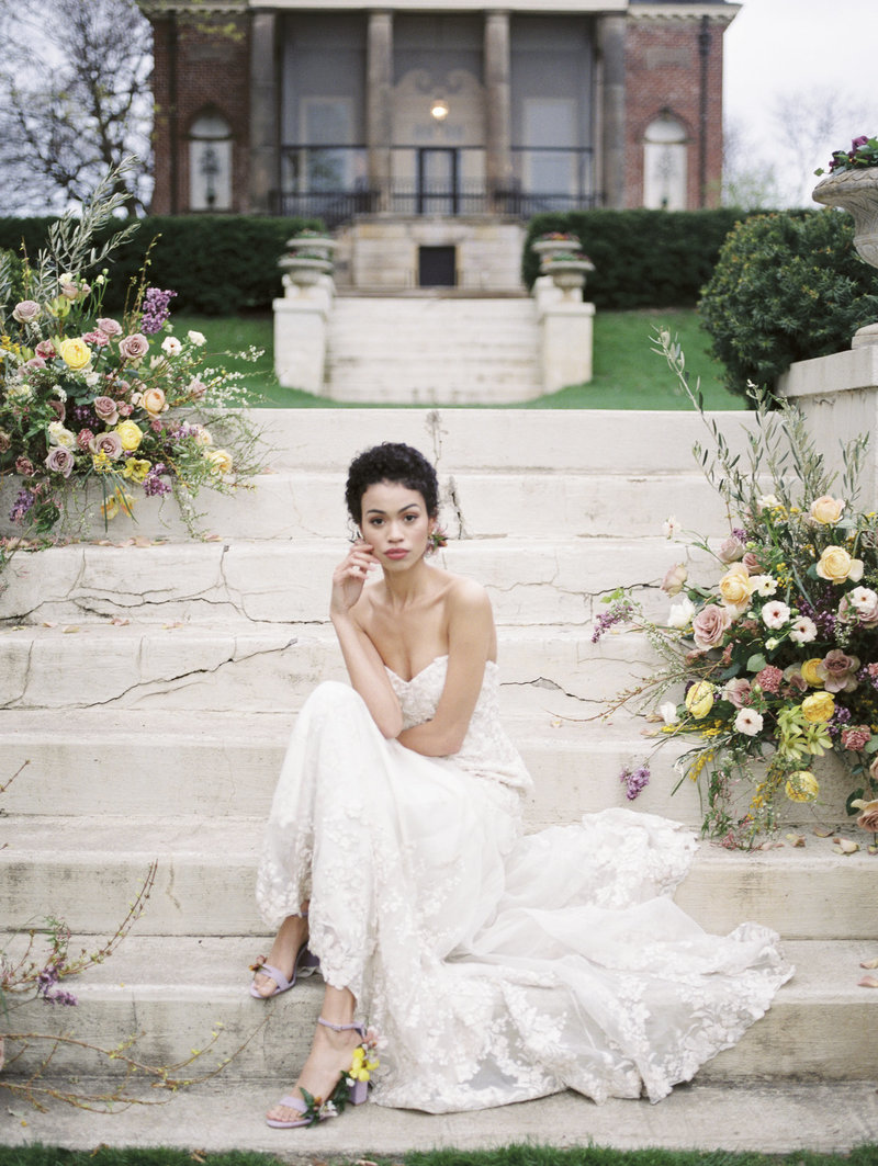 bride sitting on steps with florals from South Bend florist