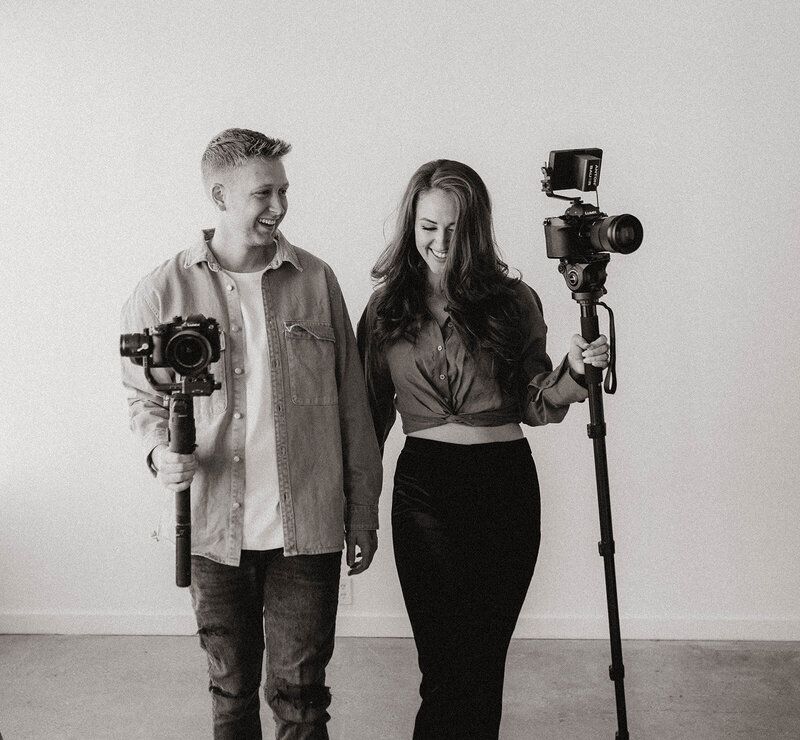 couple holding camera equipement