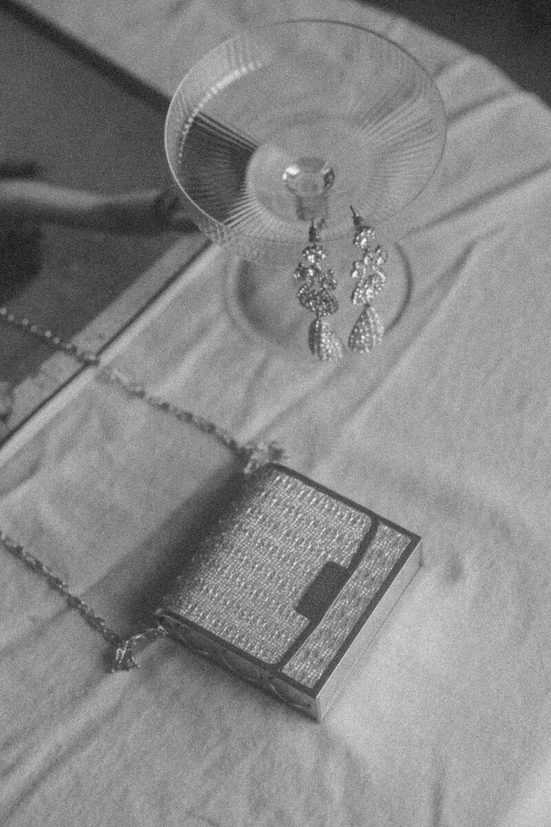 Black and white photo of a champagne glass and an elegant small bag