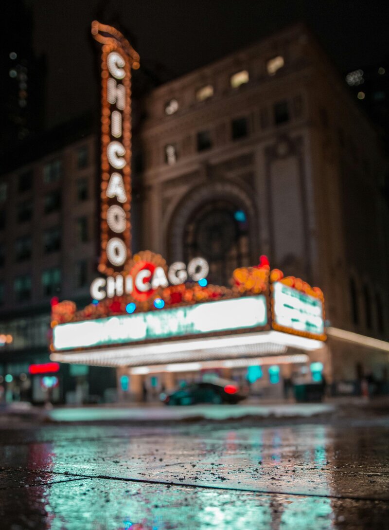 a near-focused shot of the chicago theatre marquee at night in the rain