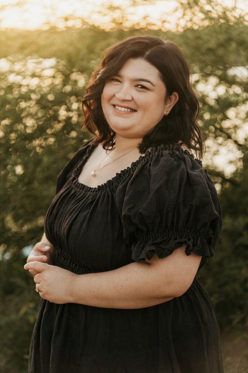 A person smiling and standing outside  