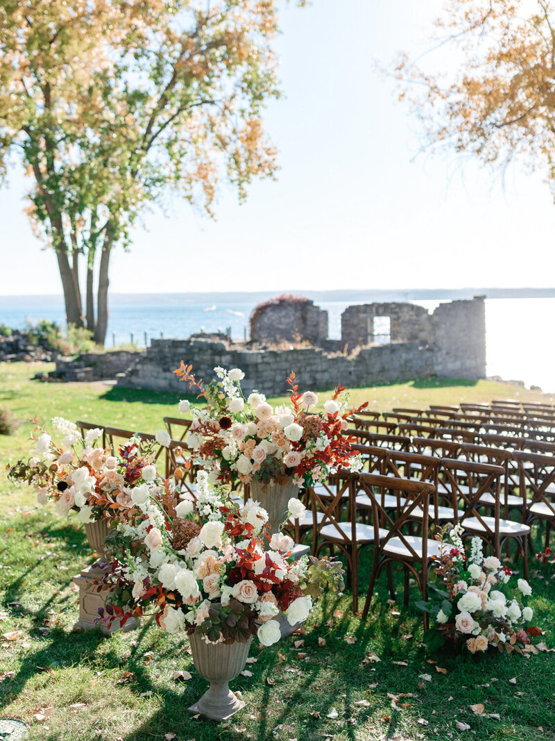 Elegant fall florals and wedding aisle of Inns of Aurora in update New York. Stone ruins and finger lakes in the background.