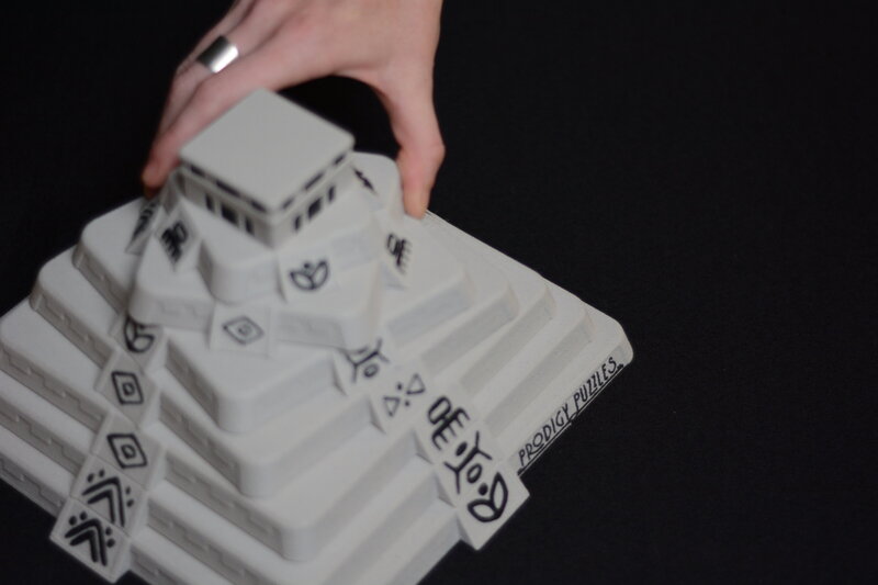 A hand twisting a pyramid puzzle that is similar to the pyramids in Mexico