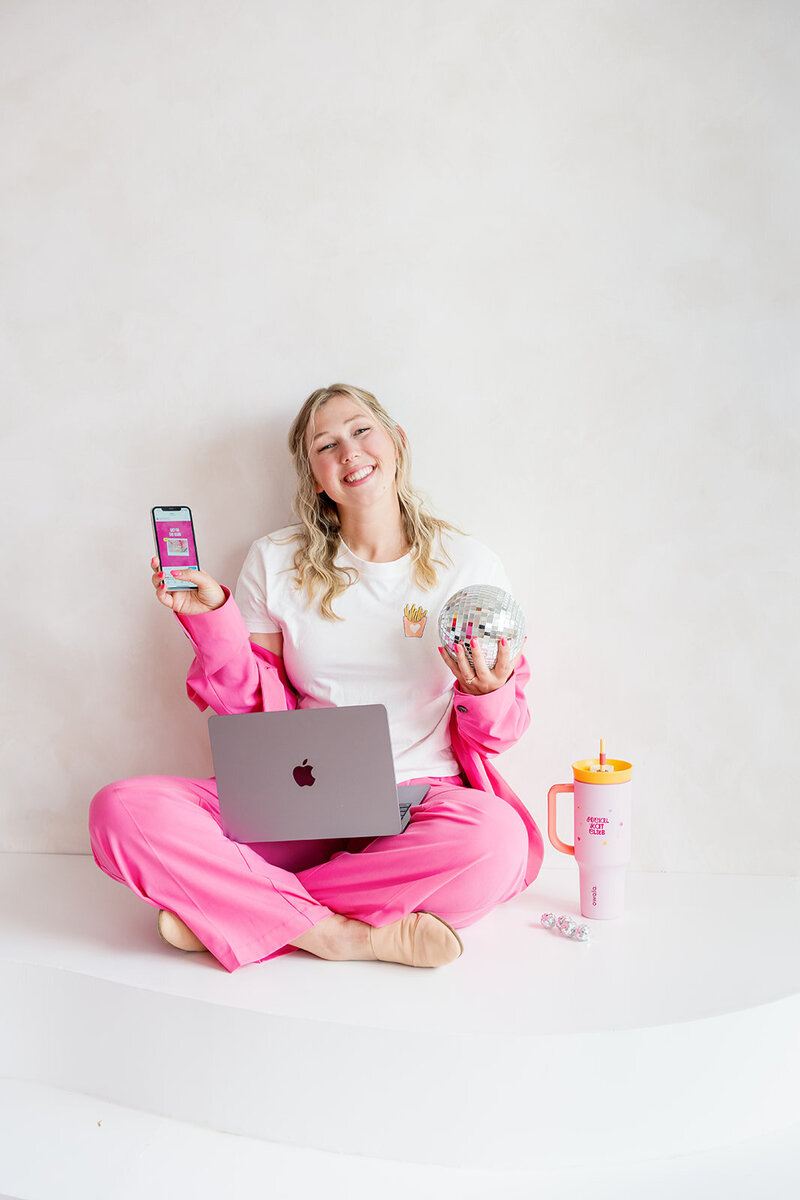 Hand with a pink sleeve holding up a phone with an Instagram grid on the screen