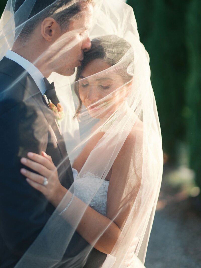 Wedding Couple embracing under a veil during their Destination Wedding in Tuscany