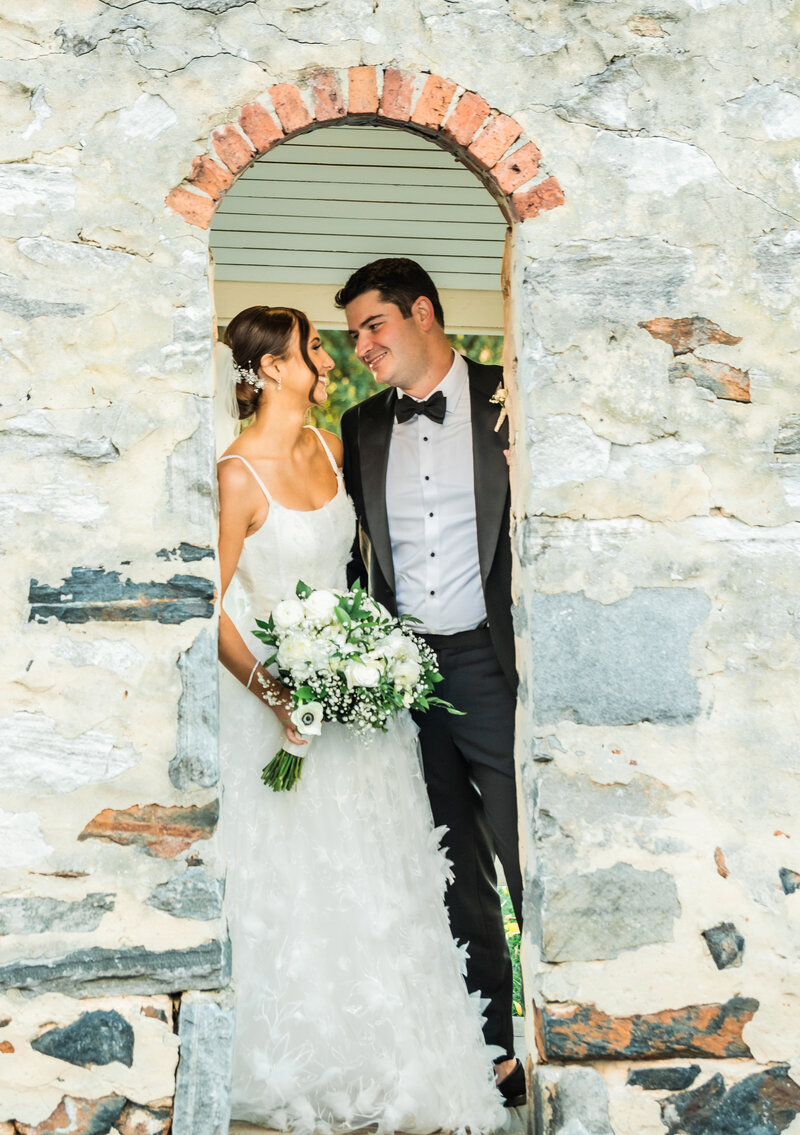 Photo of bride and groom at stone wall of Baltimore County Club, Wedding Roland Park