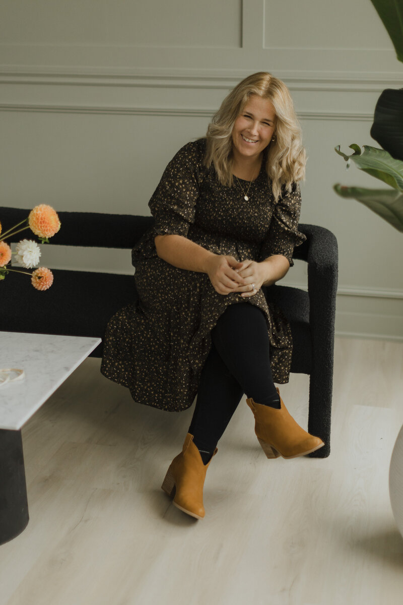Image of Jenny (Owner) sitting on a couch laughing.