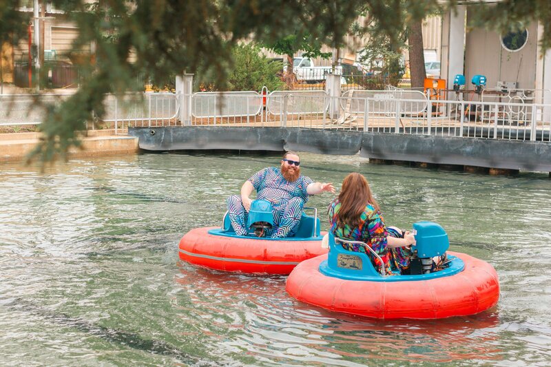 Two people floating in water in bumper boats.