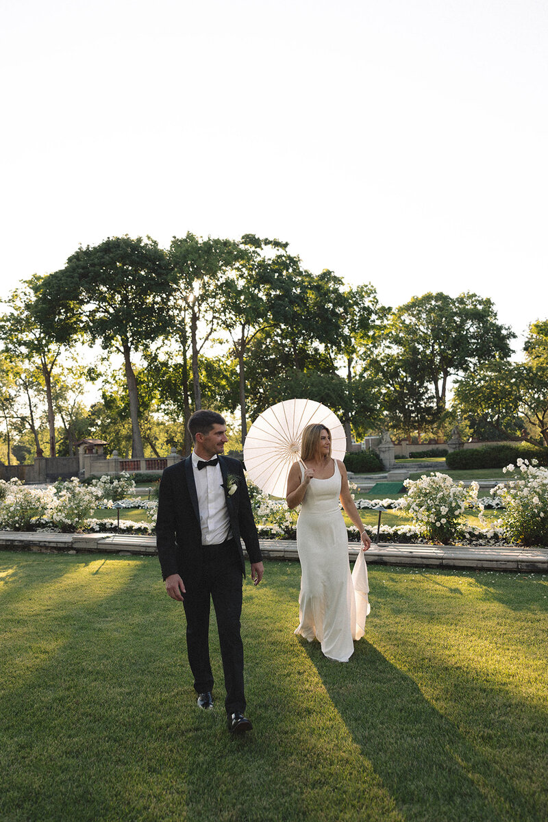 Close-up of a bride and groom holding a bouquet of white roses, symbolizing purity and commitment on their wedding day.