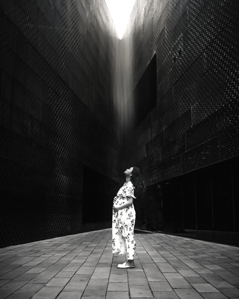 San Francisco pregnant mama looks toward light at De Young Museum. Photo in black and white