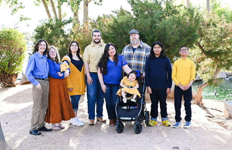 A large family standing together in a desert garden.