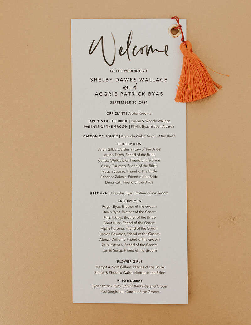 Ceremony program with calligraphy and finished with a gold grommet and tassel