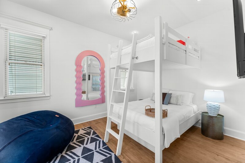 Bright bunk bedroom with colorful mirror and bean bag in Panama City Beach vacation home.