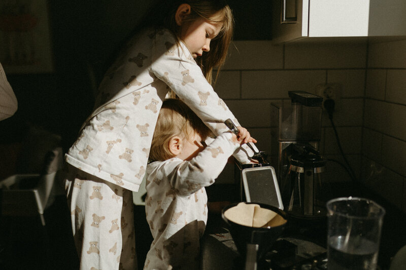 En gravid mamma myser med sina barn under en gravidfotografering i Göteborg.
