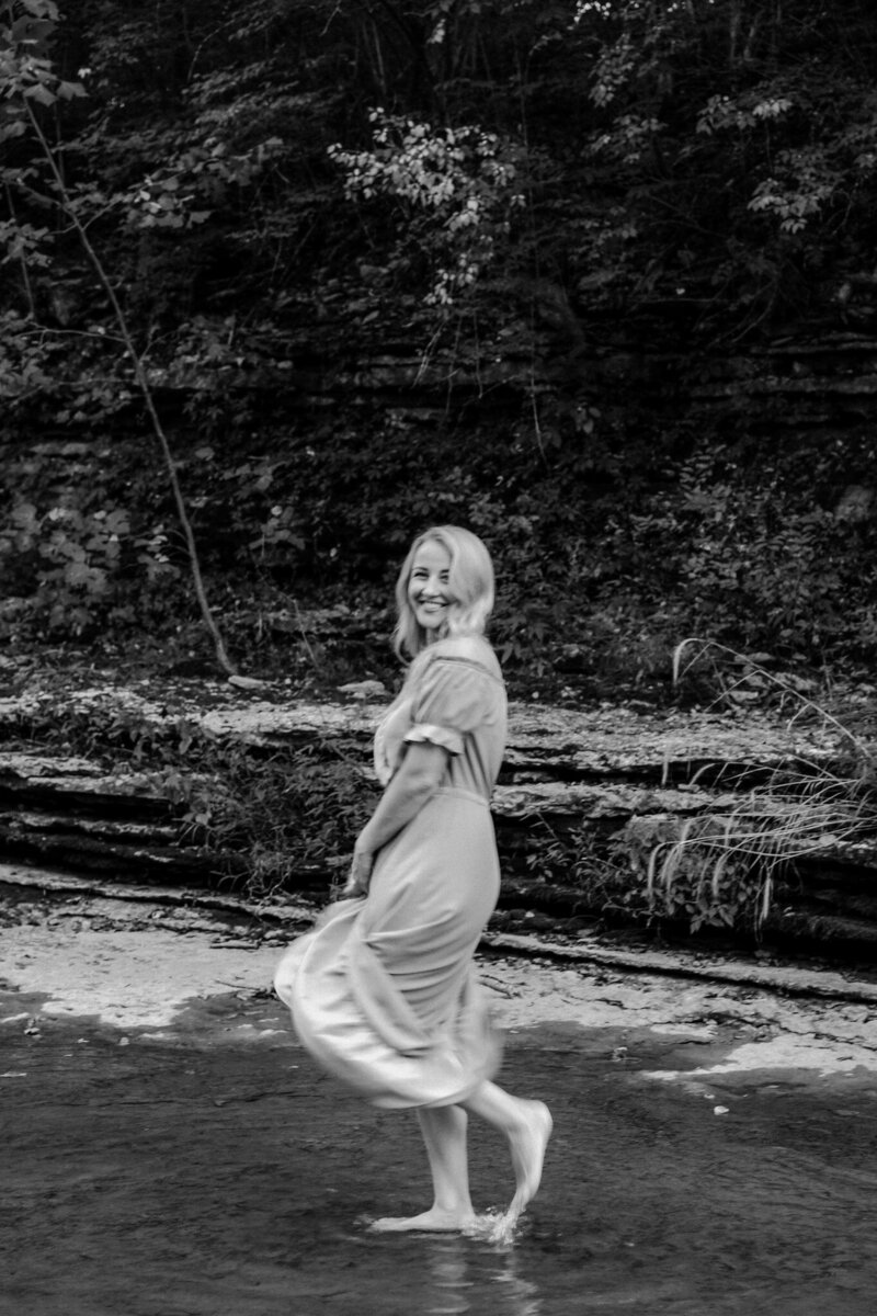woman laughing and standing in a creek