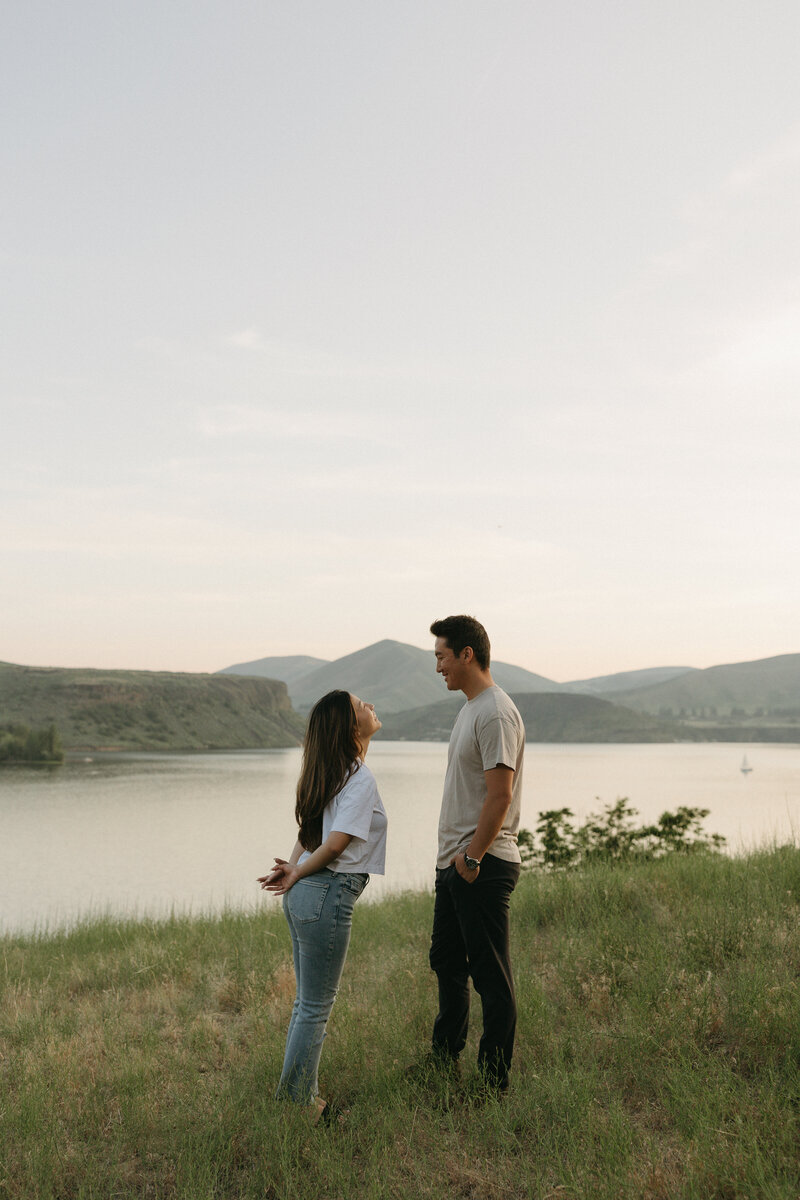 Couple smiling atop mountain with lake view