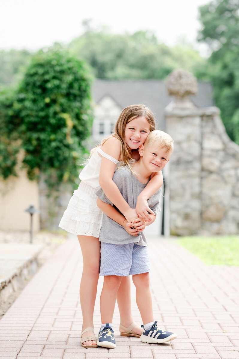 Siblings hugging at a family session outdoors