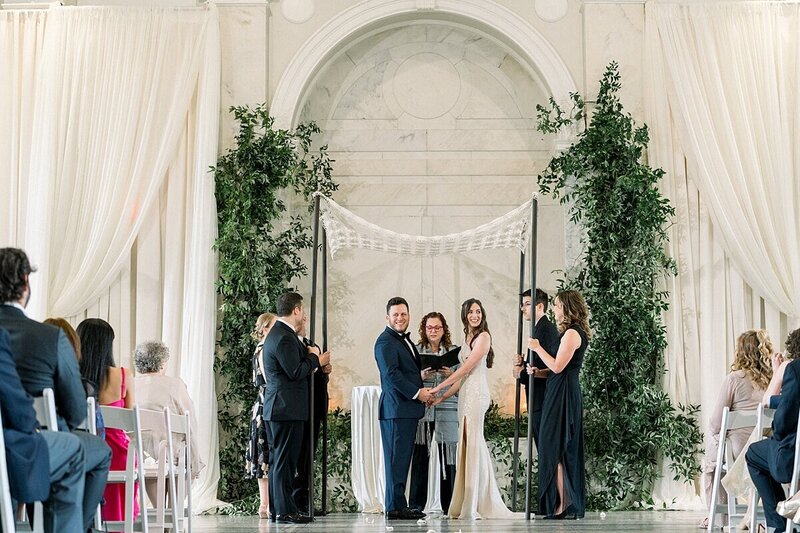 Couple smiling at there guest from their Chuppah