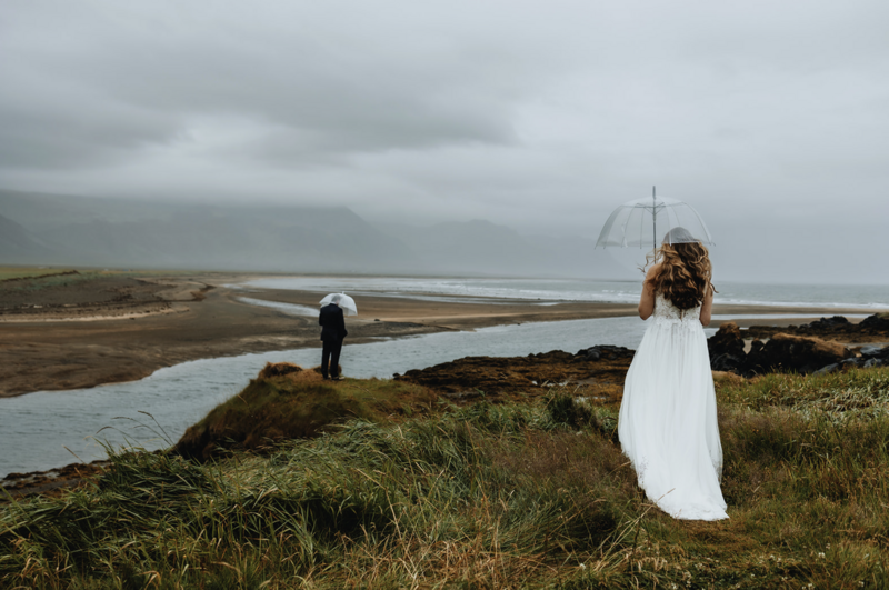 first look of a couple in a rainy moody weather with beautiful view in Iceland on their wedding day