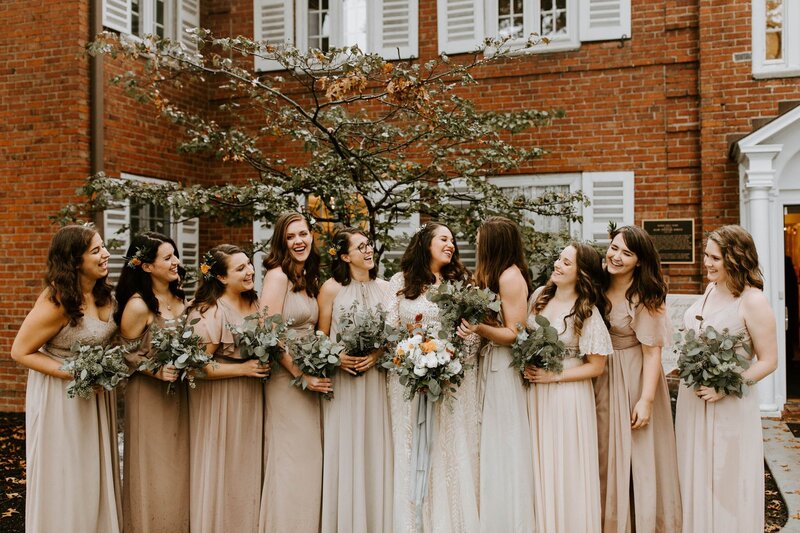 bride smiling and standing with her bridesmaids