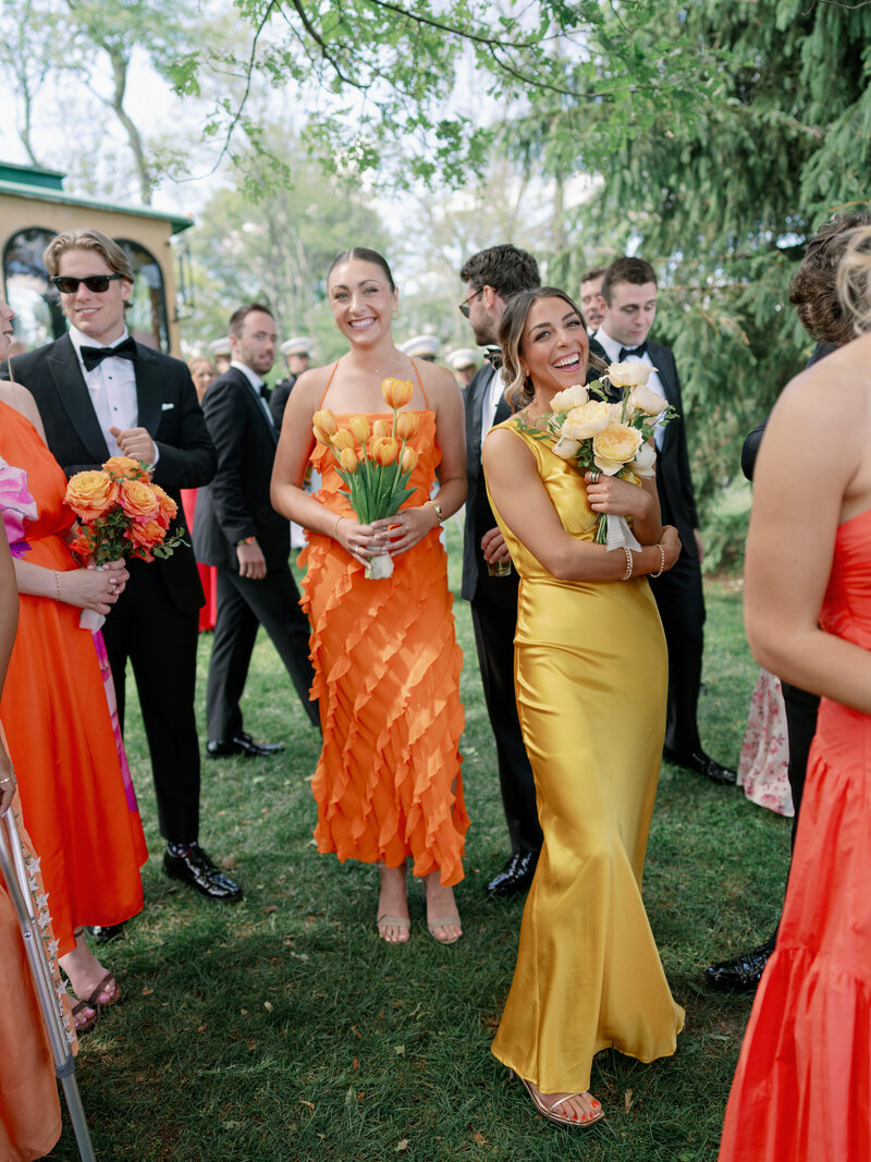 Bridesmaids in mismatched colorful gowns with monochrome flowers for a destination wedding in the mountains at Cedar Lakes Estate