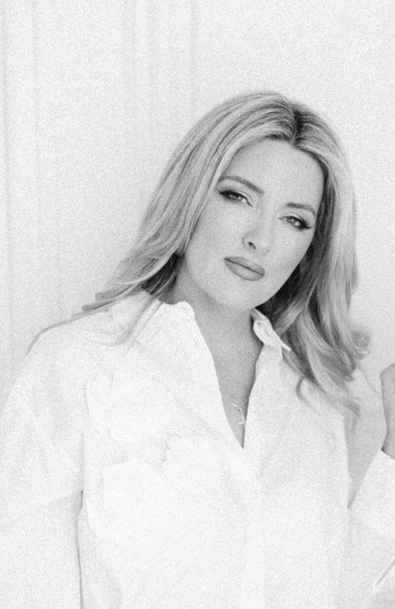 Black and white portrait of Christine Grace in a white blouse, looking confidently at the camera—fine art photographer based in Burlington, Ontario.