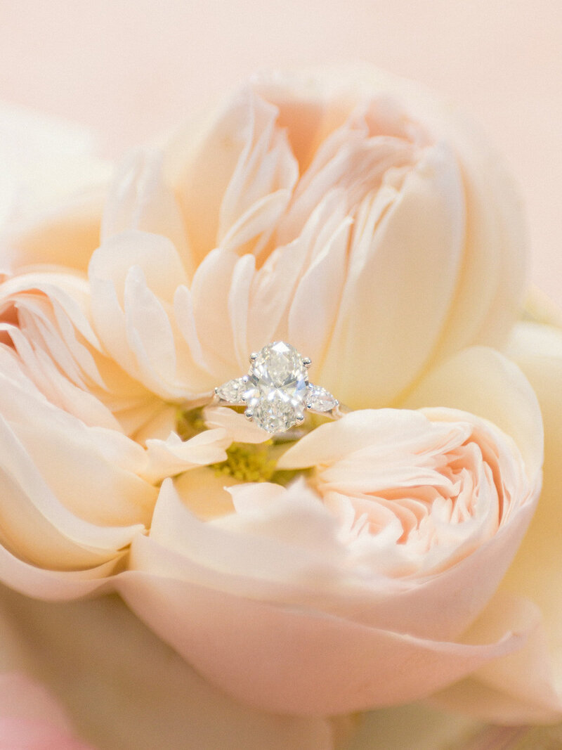 Woman poses for engagement with diamond ring outside the Swan House