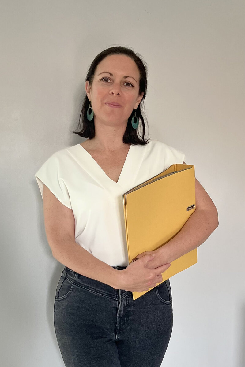 Photo of Caroline Kerhom-Nookala holding a yellow folder
