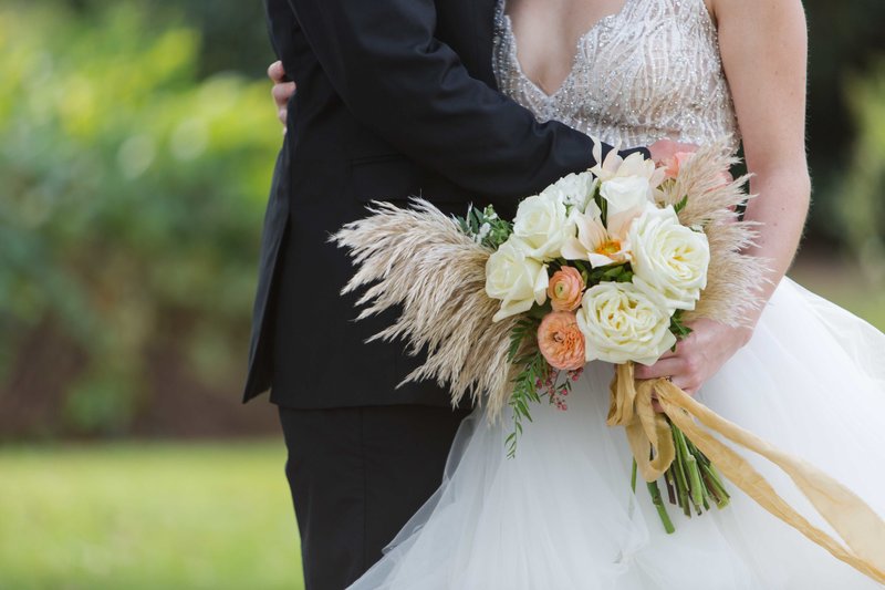 Great Gatsby inspired wedding couple embrace with bouquet at Parterre