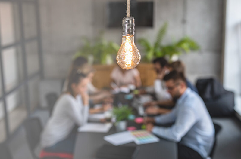 Lightbulb over a small group gathering