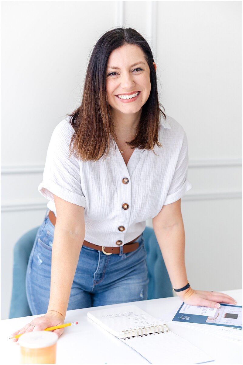 woman standing at a desk with a pencil and notebook discussing website copywriting packages
