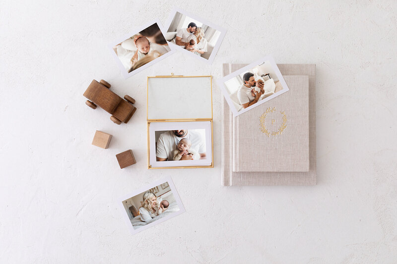 prints and albums laying on a white table with children's toys