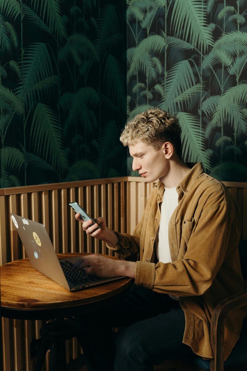 Man working in front of computer writing on paper