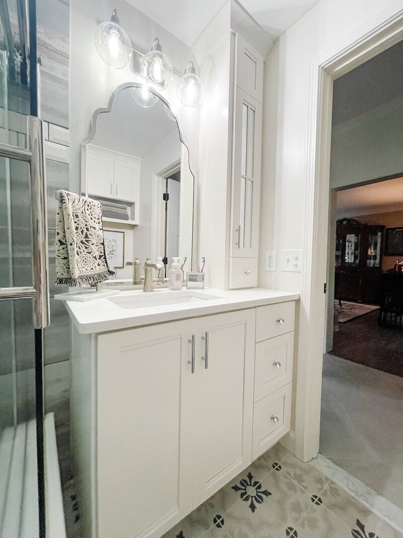 Bright white bathroom with a playful mirror with scalloped edges