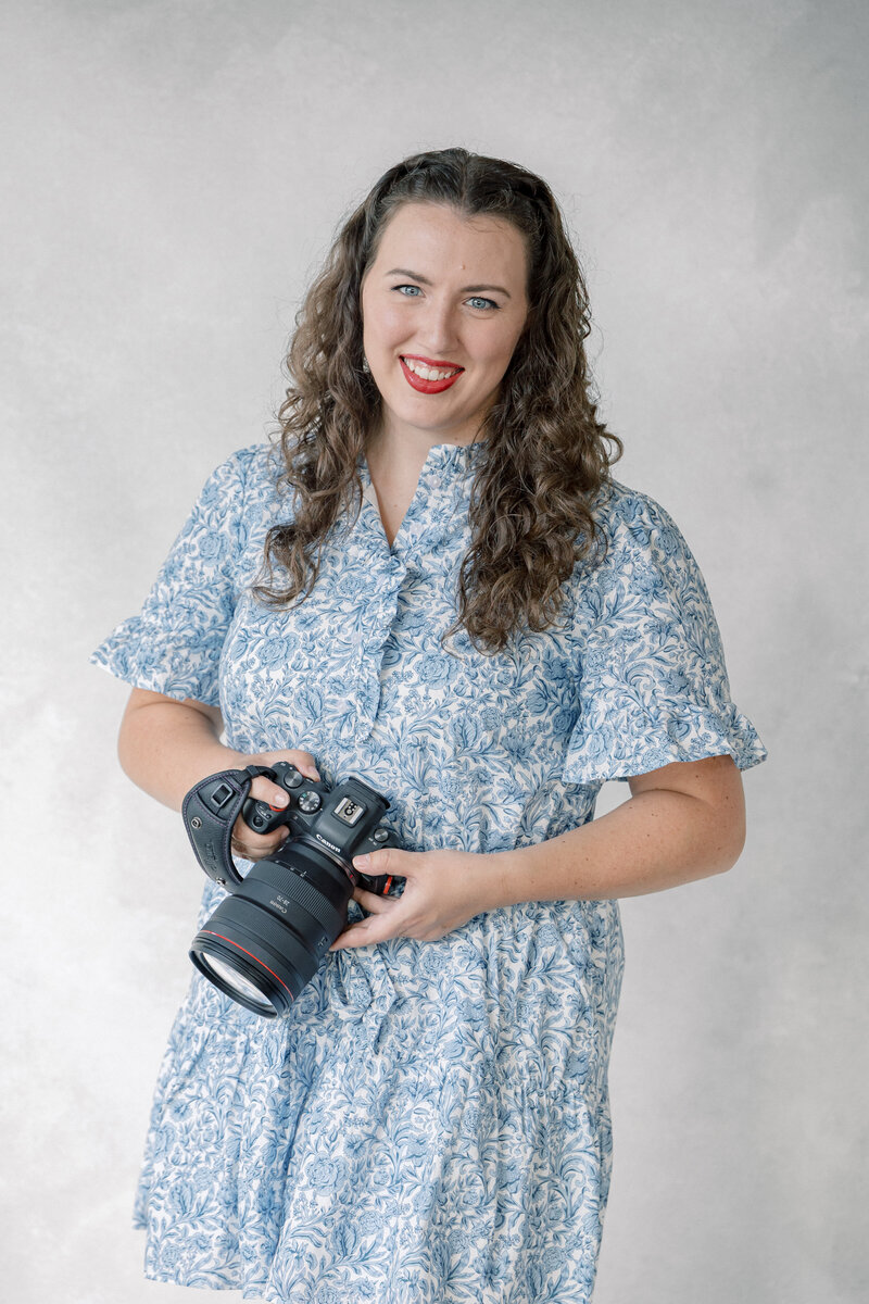 Atlanta Fine Art Wedding Photographer | Portrait of a Georgia wedding photographer named Emily who photographs weddings, elopements, proposals, and engagement sessions in the Atlanta, Savannah, and North Georgia area. She is smiling with her mirrorless camera in hand, ready to meet newly engaged couples and capture these once in a lifetime memories for them in a way that is artful, timeless, effortless and genuine – through a blend of documentary style and editorial style fine art photography in Atlanta