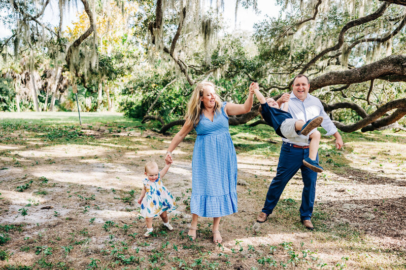 Family enjoying holiday mini session under ancient oak trees at Philippe Park.