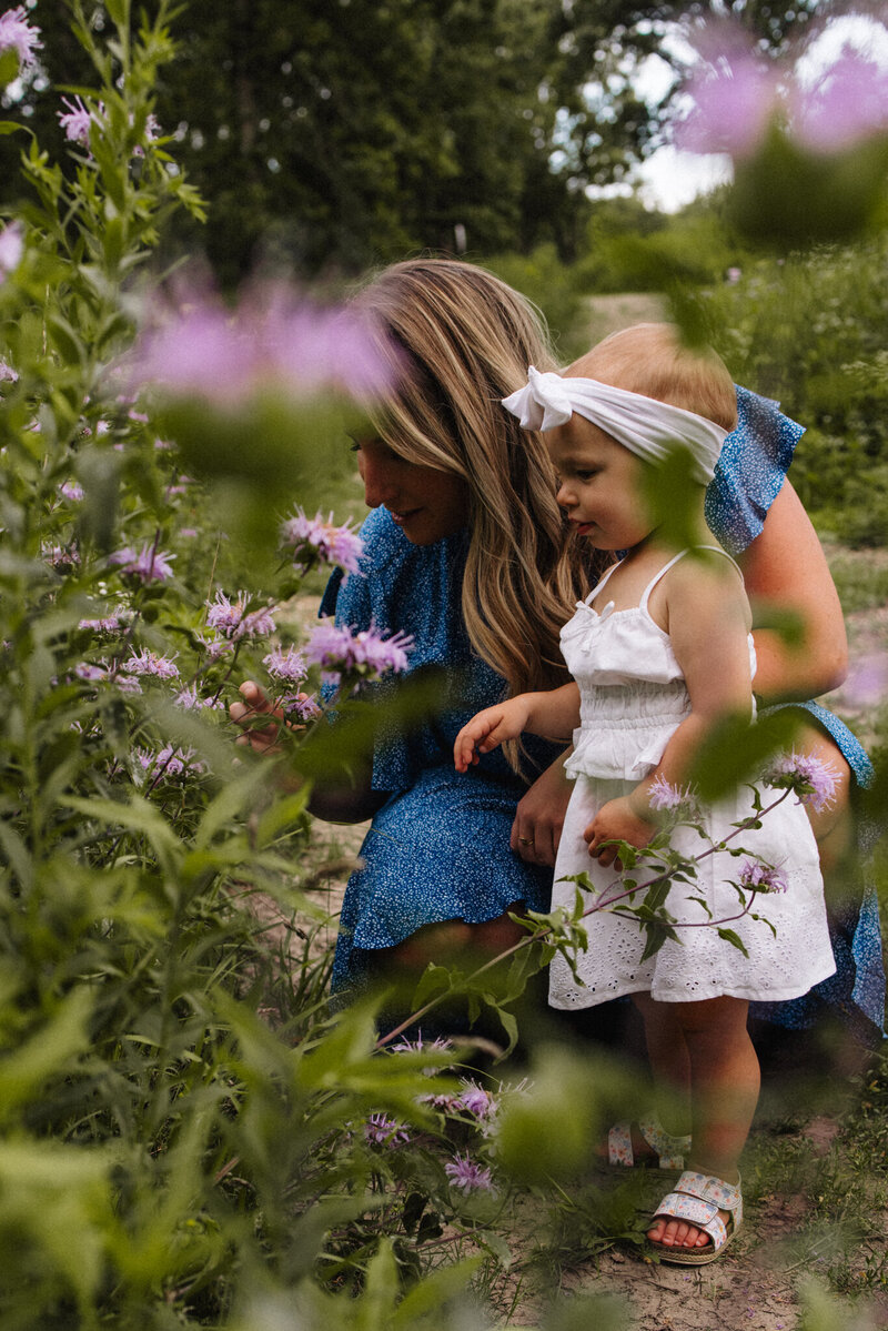 Mother and toddler daughter smelling flowers at the Morton Arboretum.