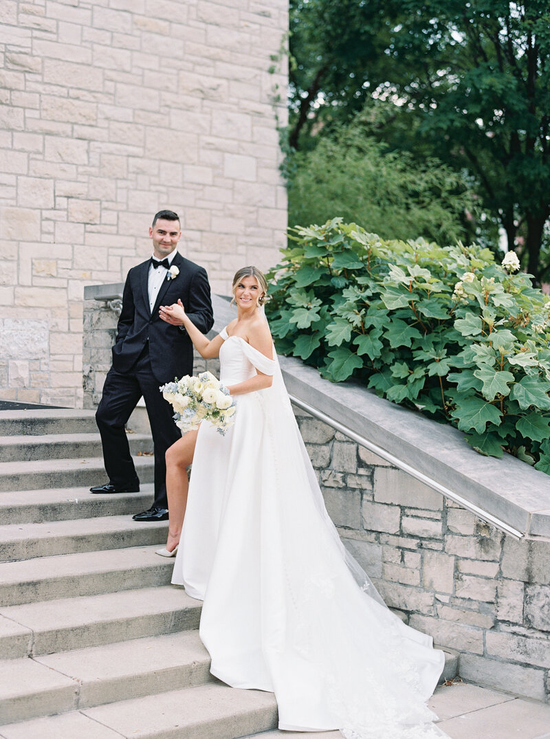 groom escorting bride up steps at Midwest wedding venue, Immaculate Heart of Mary