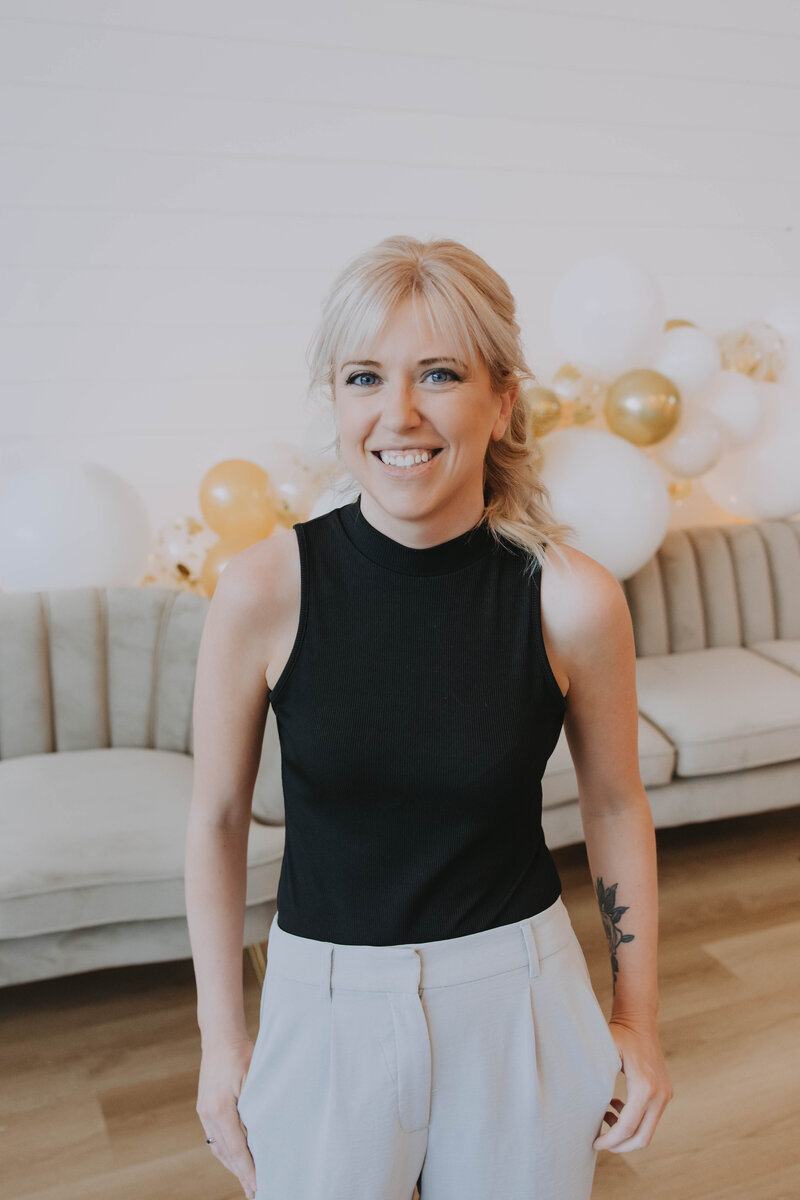 Event planner in cozy winter outfit and grey beanie smiling in snowy Banff forest – Rocky Mountain Wedding Collective