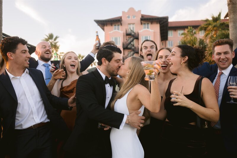 Bridal couple at their wedding, surrounded by friends, by Galveston wedding planners Water to Wine Events.