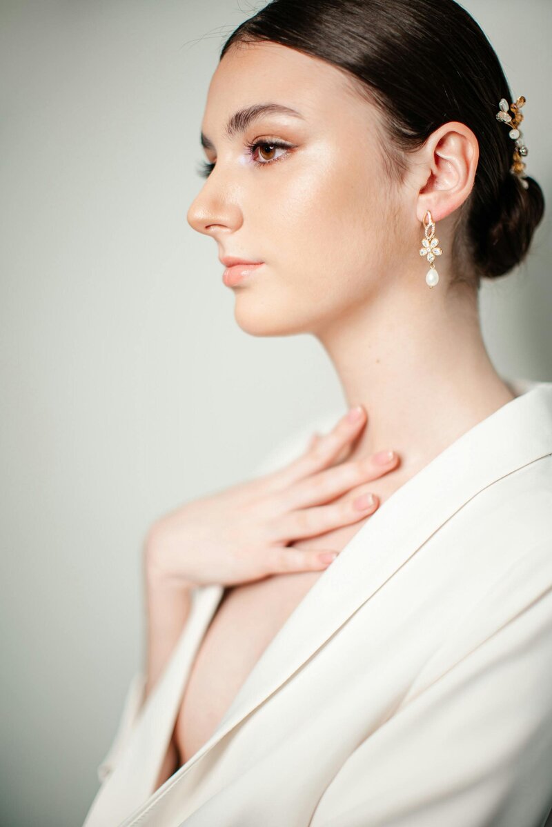 Bride with a sleek, elegant low bun and radiant soft glam makeup, ready for her wedding day.