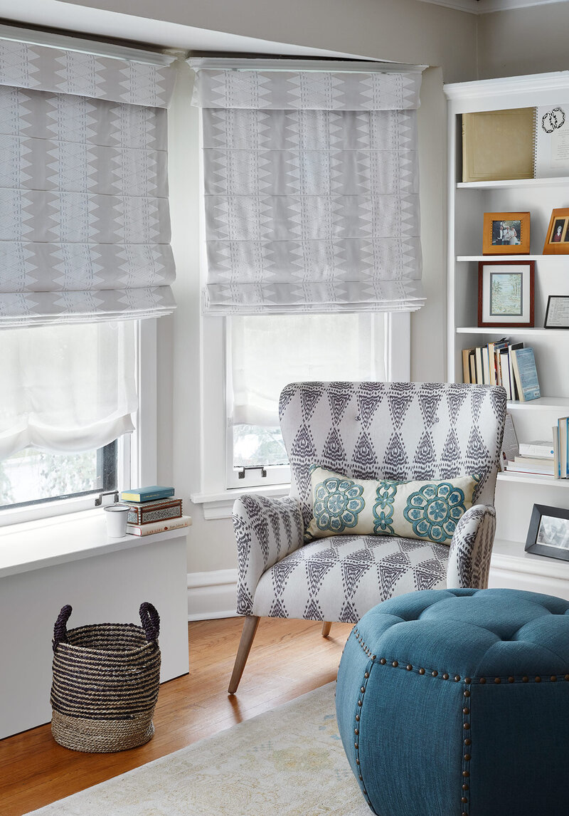 Grey and white patterned chair in living room with built in shelves
