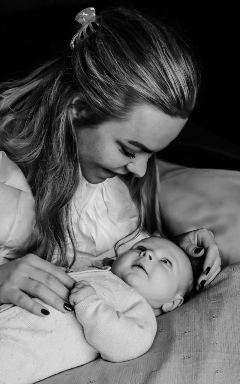 Een ontroerend portret van een moeder en haar pasgeboren baby, waarbij de nadruk ligt op hun intieme verbinding.