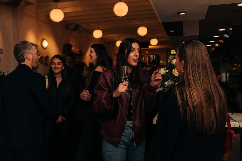 Friends toasting and celebrating during Dart Collective Chicago launch at Lou Lou by Lola Cafe