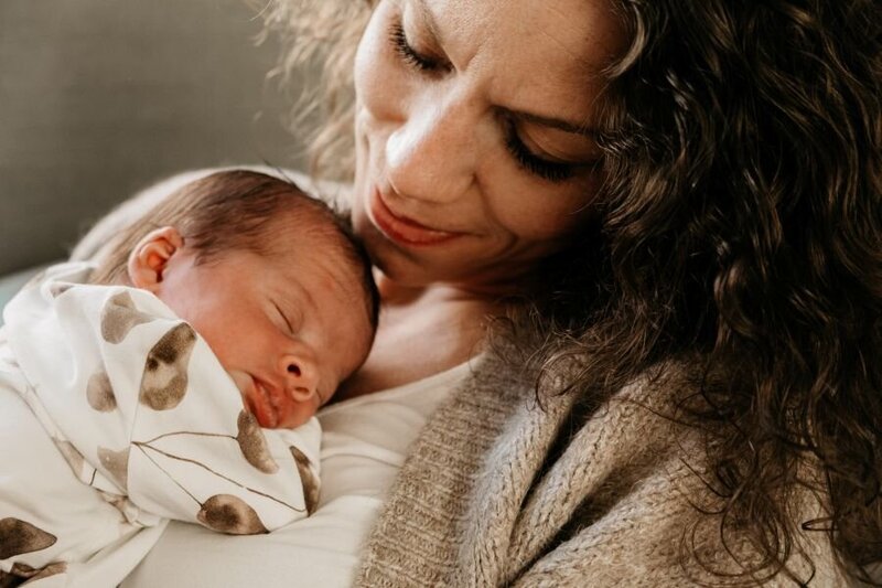 Foto van de handen van papa, mama en de baby tijdens een fotosessie in de natuur in Ede. 